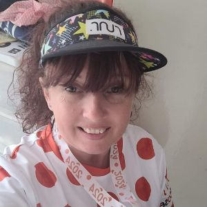 Smiling woman wearing a running visor and a polka-dot race shirt