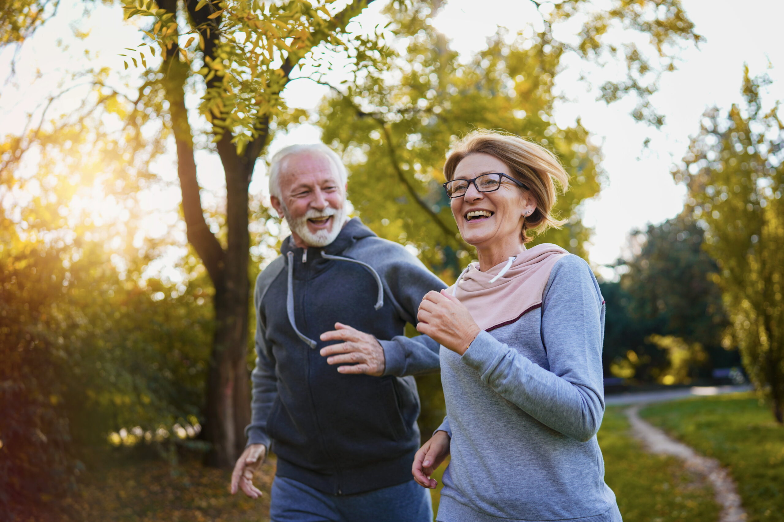 How Running Can Boost Your Mental Health Male and female runners smiling as they run